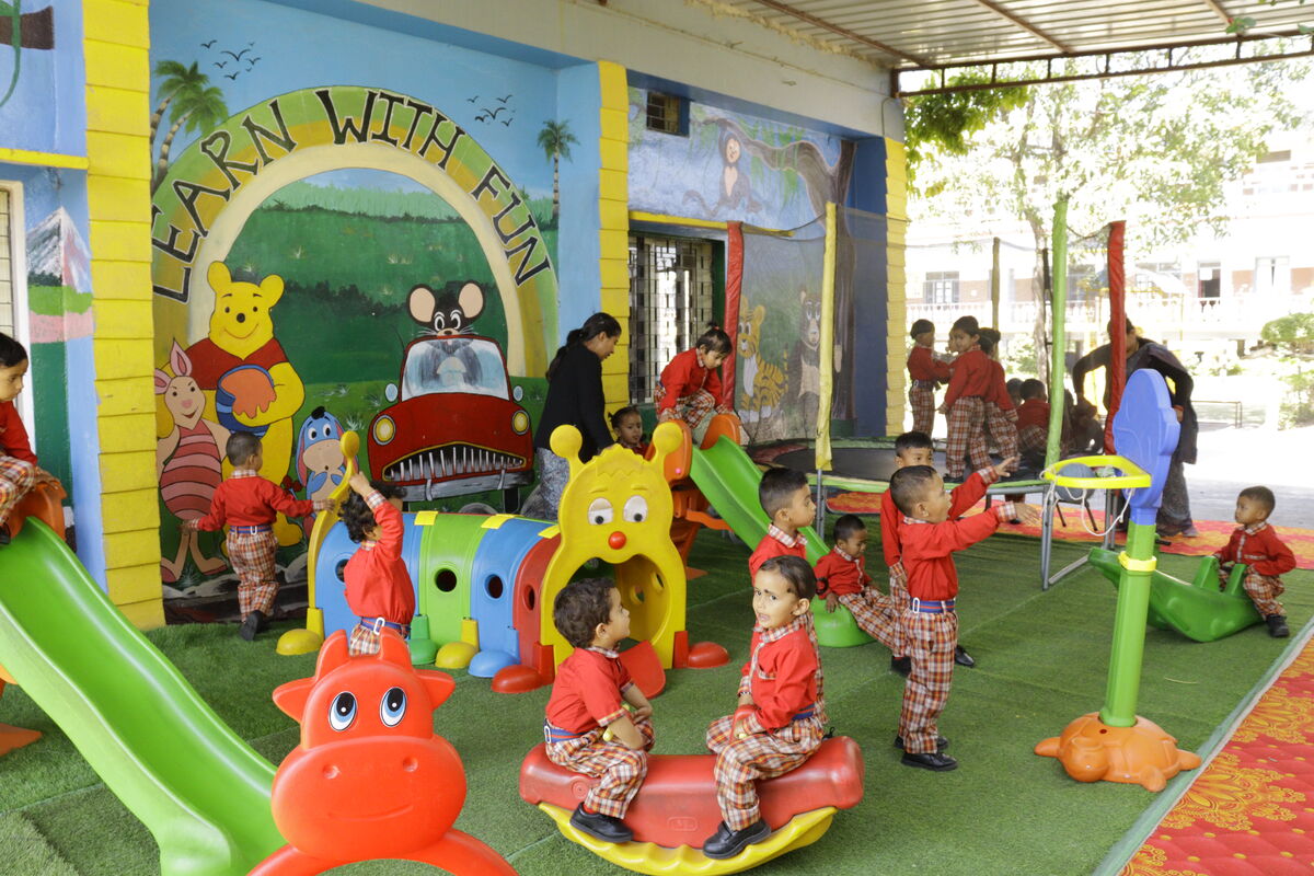 Wide view of 'Learn With Fun' play zone with slides and swings